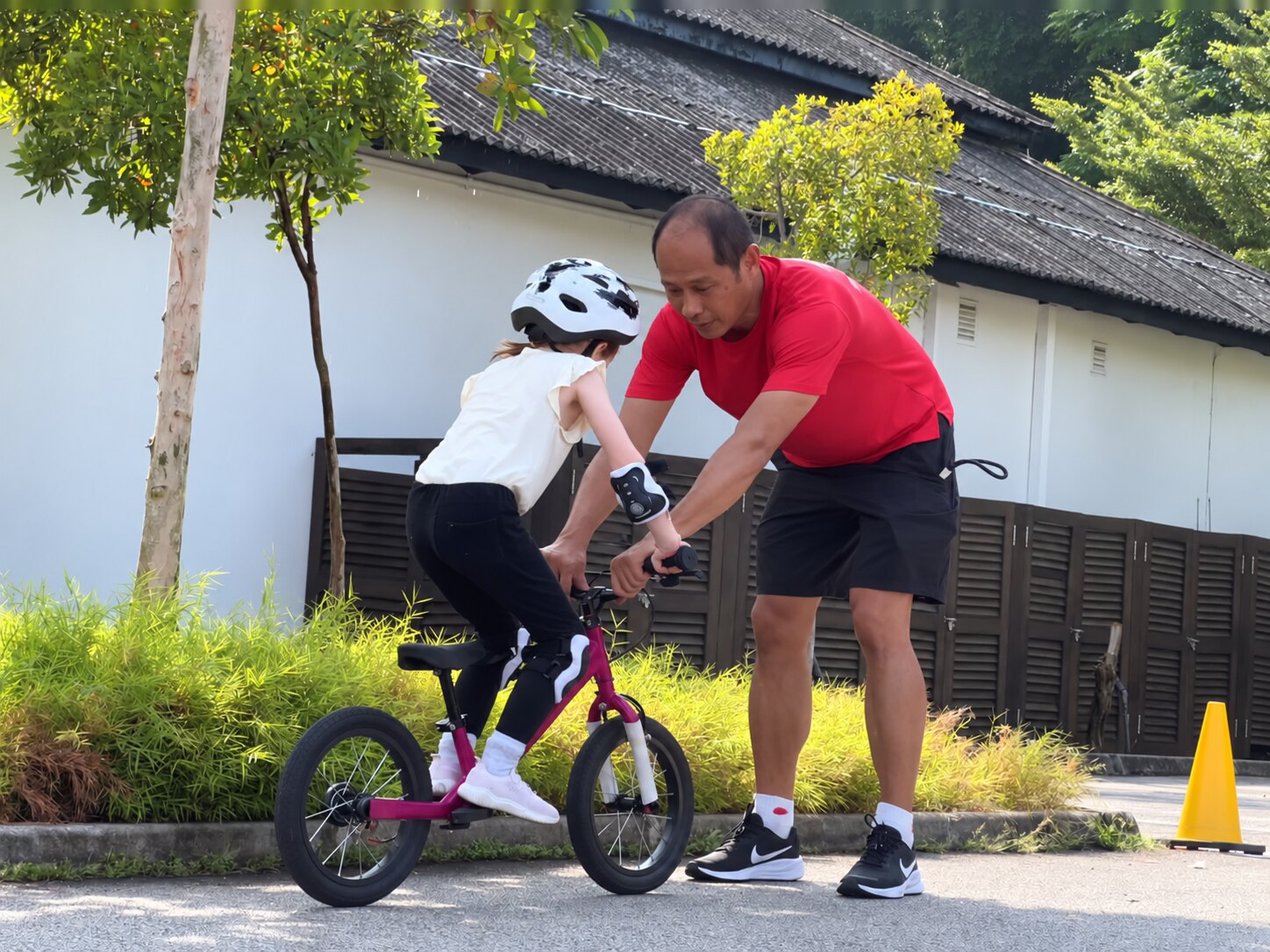 A MooOink Active coach helping a child practise balance-bike skills