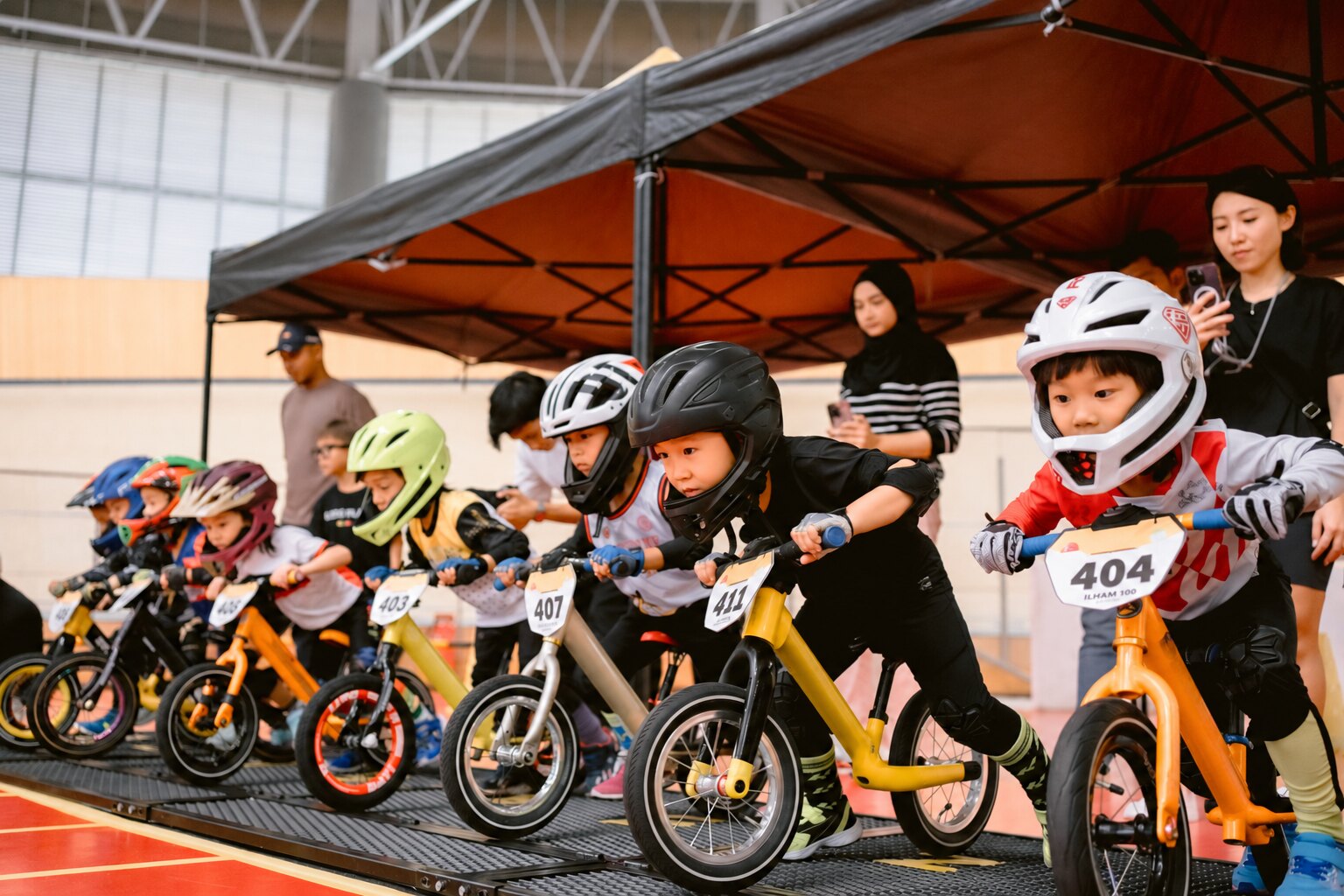 Young balance-bike riders ready at a community race